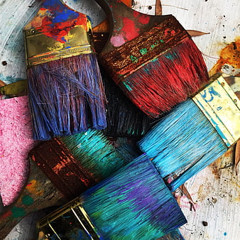 Colorful Paintbrushes and Sponge on Wooden Background