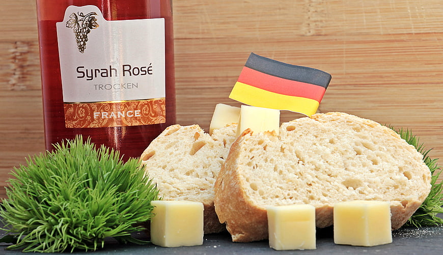 Syrah Rosé Wine, Baguette Slices, Cheese Cubes, and German Flag Still Life