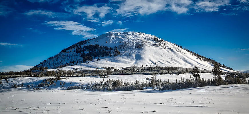 Snow-Covered Mountain Peak Under Blue Sky