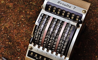 Vintage mechanical calculating machine with numbered dials and metal frame