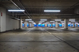 Empty Underground Parking Garage With Concrete Columns And Fluorescent Lighting