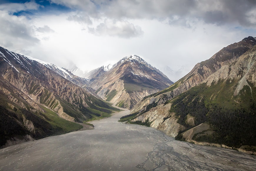Majestic Mountain Valley with Glacial River and Snowy Peaks