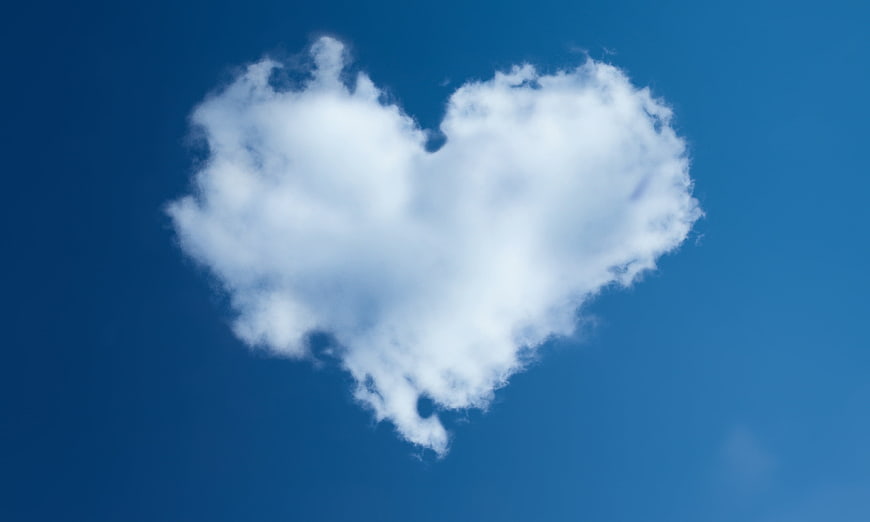 Heart-shaped white cloud in blue sky