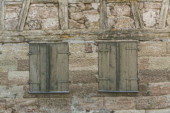 Weathered Wooden Shutters On Old Stone Building Facade
