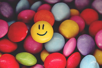 Yellow Smiley Face Candy Among Multicolored Sweets