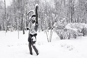 Snow-covered statue of a boy in a winter park
