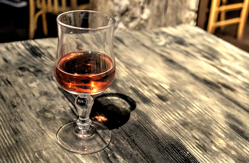 Glass of Amber Spirit on Rustic Wooden Table
