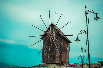 Historic wooden windmill in Nessebar old town against teal sky