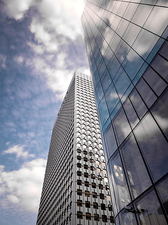 Low angle view of modern glass skyscrapers against blue sky
