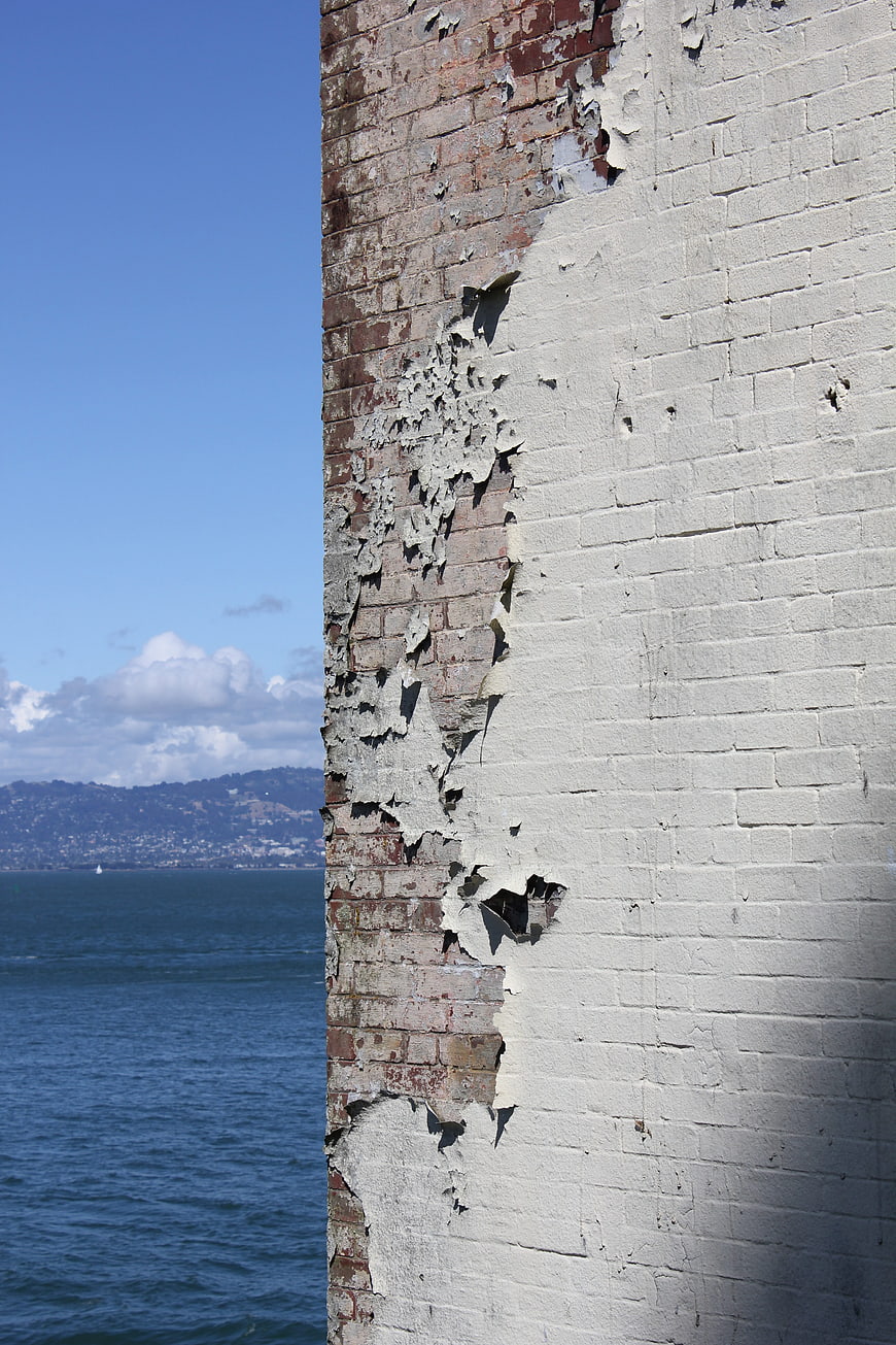 Weathered Brick Wall with Peeling Paint and Ocean View