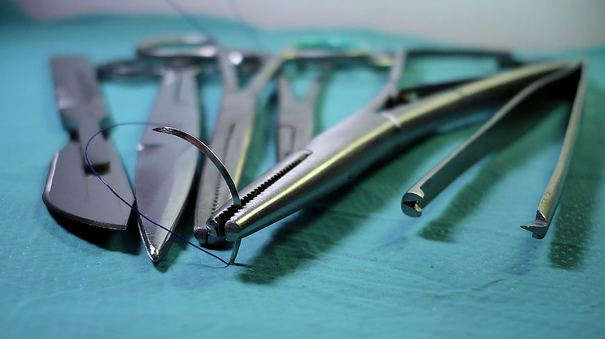 Close-up of surgical instruments on green medical cloth