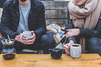 Couple drinking coffee outdoors in winter jackets