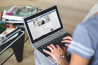 Woman typing on laptop browsing interior design blog