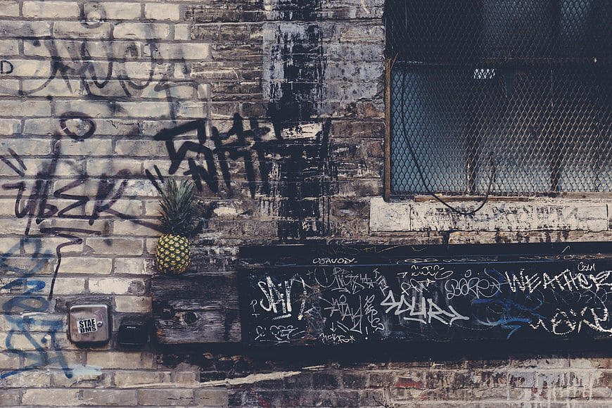Pineapple on Graffiti-Covered Brick Wall