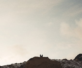 Silhouettes of Two People on Rocky Mountain Peak