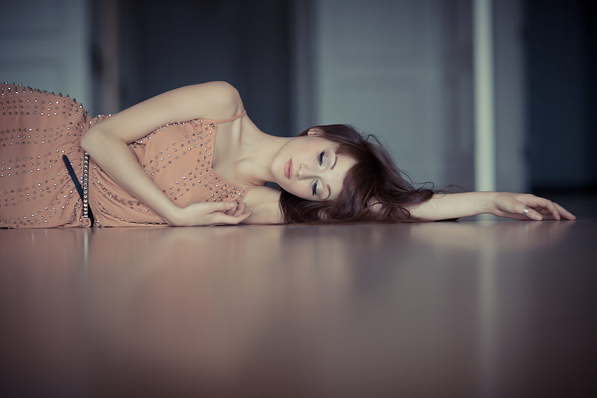 Elegant Woman Lying on Polished Floor in Beaded Dress