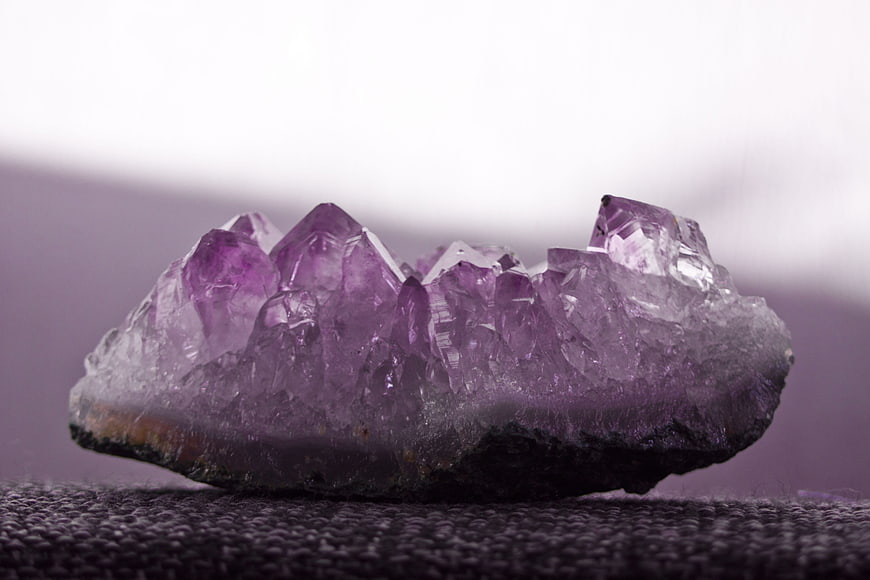 Raw Amethyst Crystal Cluster On Textured Surface