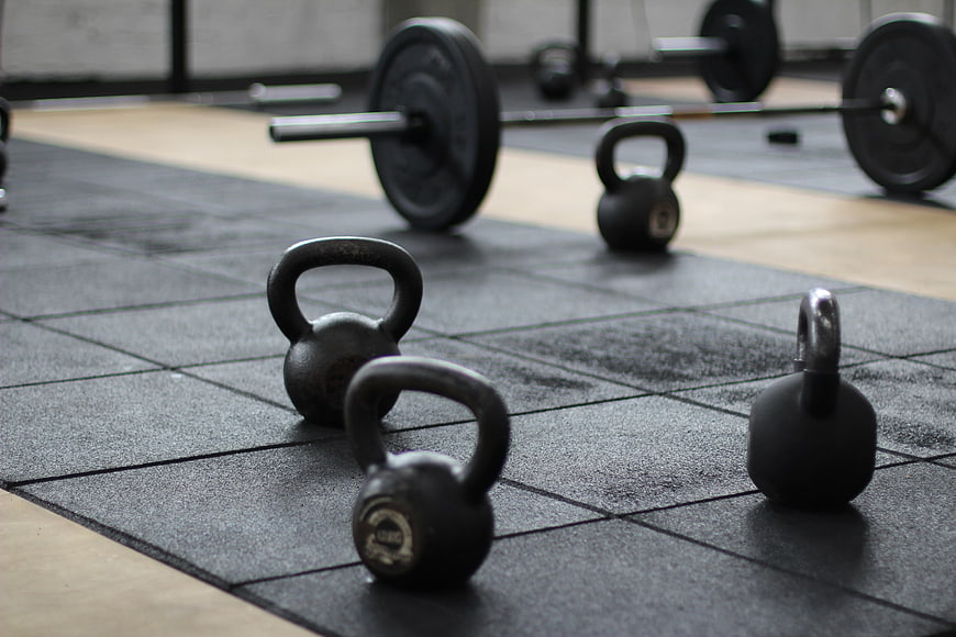 Kettlebells and Barbell on Gym Floor