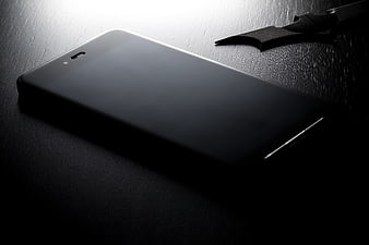 Dark moody smartphone on textured black surface