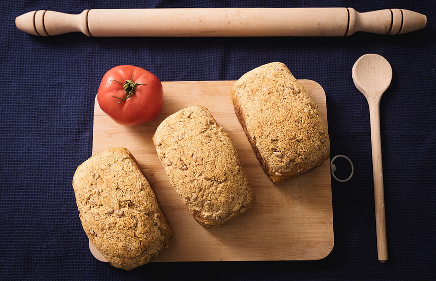 Flat lay of homemade whole grain bread loaves on wooden board