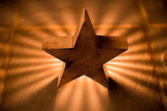 Wooden Star with Radiating Light Rays on Textured Surface