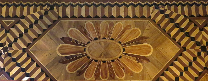 Intricate geometric wood inlay floor pattern with floral design