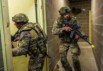 Soldiers in camouflage conducting tactical room clearing training exercise