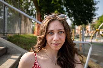 Portrait of Young Woman with Sunglasses on Head Outdoors