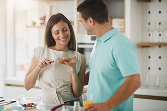 Happy couple preparing breakfast together in modern kitchen