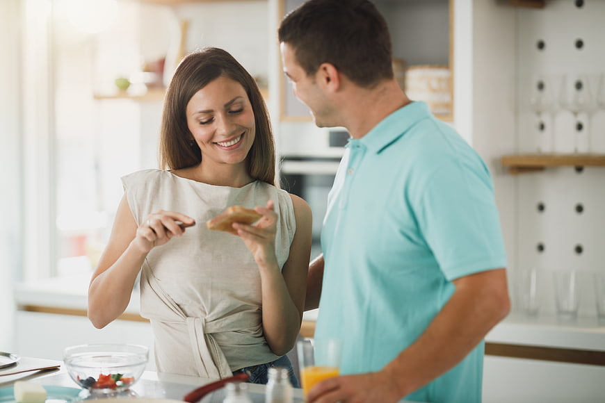 Happy couple preparing breakfast together in modern kitchen