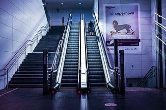 Woman Riding Escalator in Modern Indoor Architecture