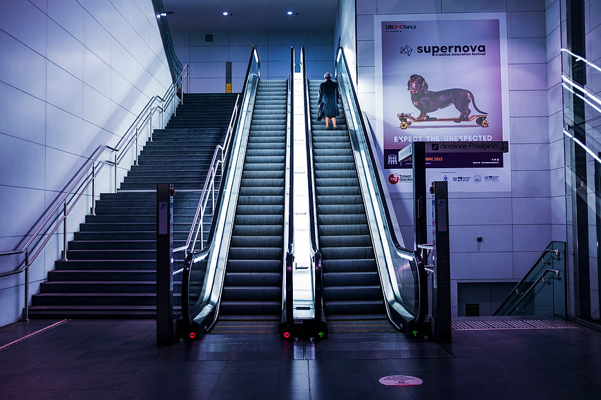 Woman Riding Escalator in Modern Indoor Architecture