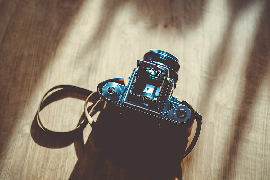 Vintage Film Camera on Wooden Table with Sunlight Shadows
