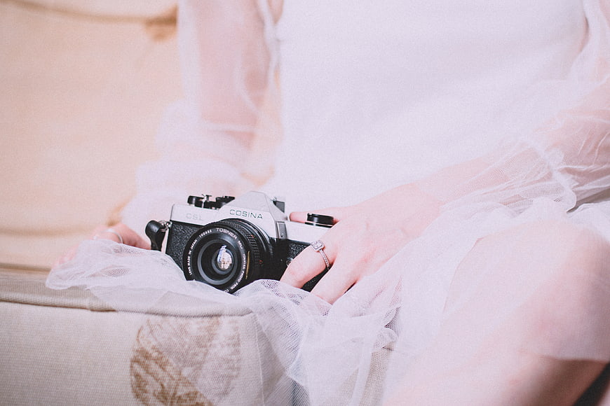 Bride Holding Vintage Film Camera in White Dress