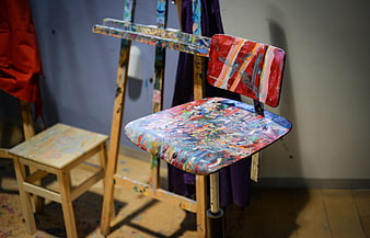 Paint-splattered wooden stool in artist studio