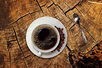 Top view of black coffee cup on rustic wooden stump
