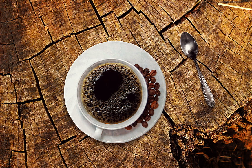 Top view of black coffee cup on rustic wooden stump