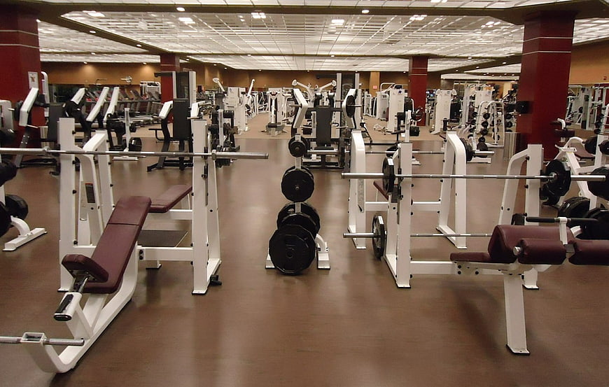 Empty gym interior with weight machines and free weights