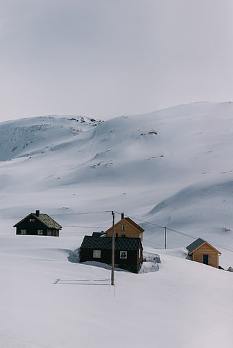 Snow-covered cabins in a remote winter mountain landscape