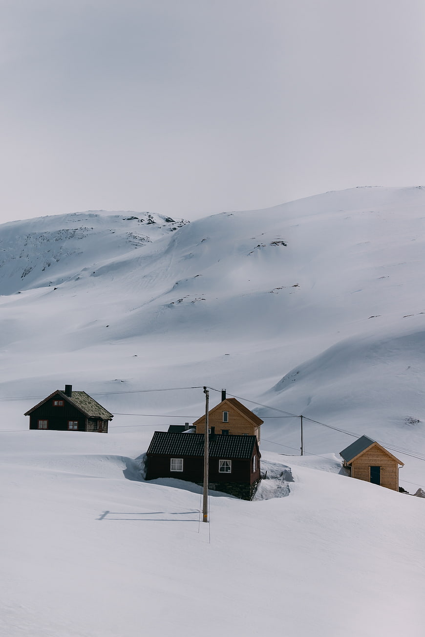 Snow-covered cabins in a remote winter mountain landscape