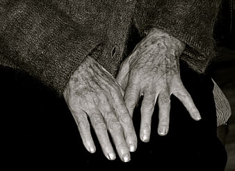 Close-up of elderly woman's wrinkled hands resting on lap