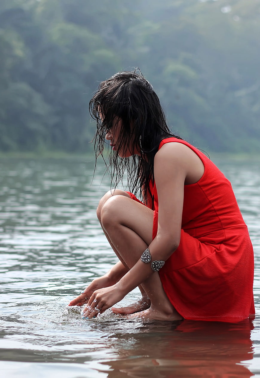 Woman in Red Dress Squatting in Lake Water