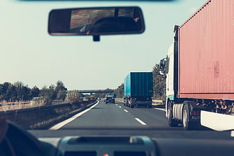 Driving on highway with trucks view from car windshield