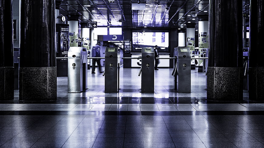 Empty subway station turnstiles with blue lighting