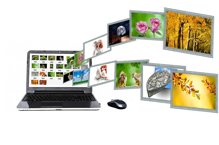 Laptop with digital photo frames flying out on white background