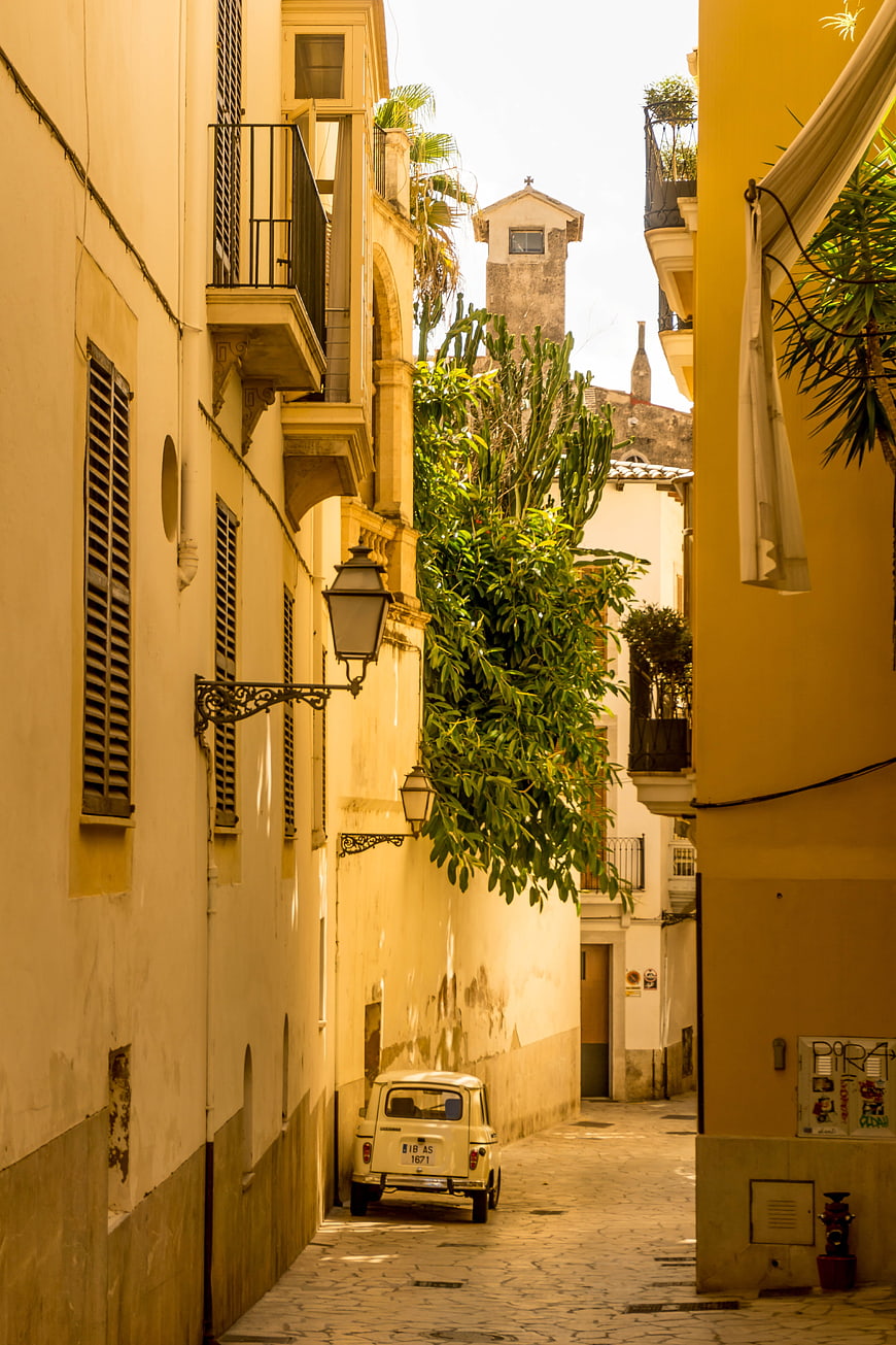 Narrow cobblestone street in Palma de Mallorca with vintage car
