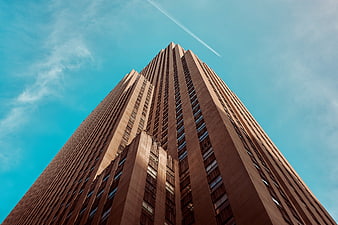 Low angle view of tall skyscraper against blue sky