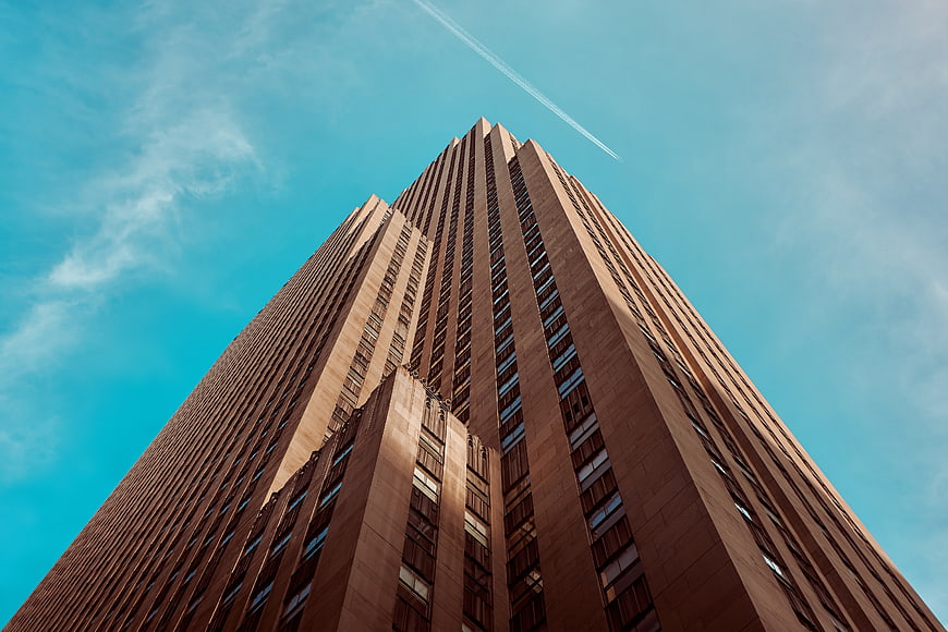Low angle view of tall skyscraper against blue sky