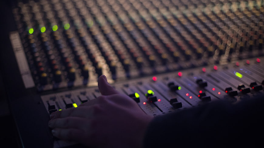 Sound Engineer Hand Adjusting Audio Mixing Console Faders