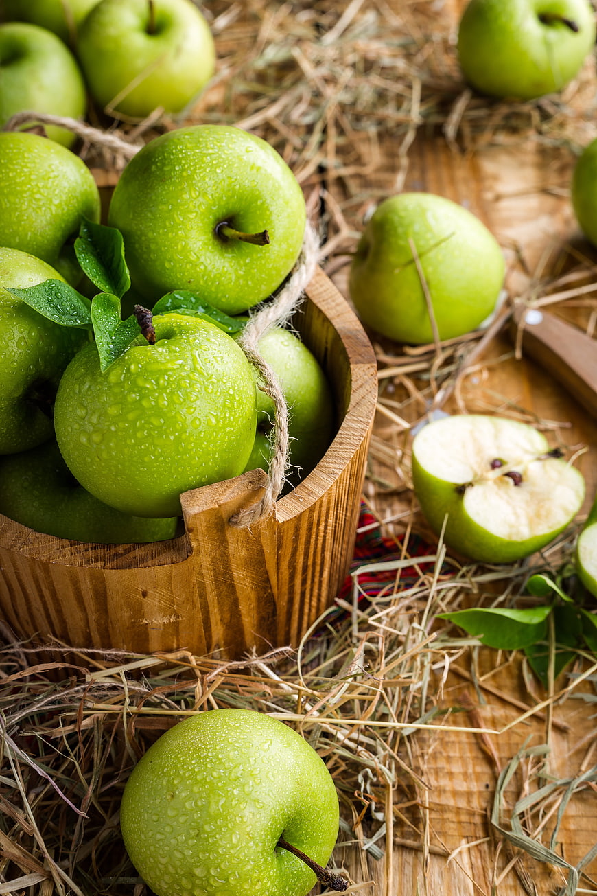 Fresh Green Apples in Wooden Bucket with Hay